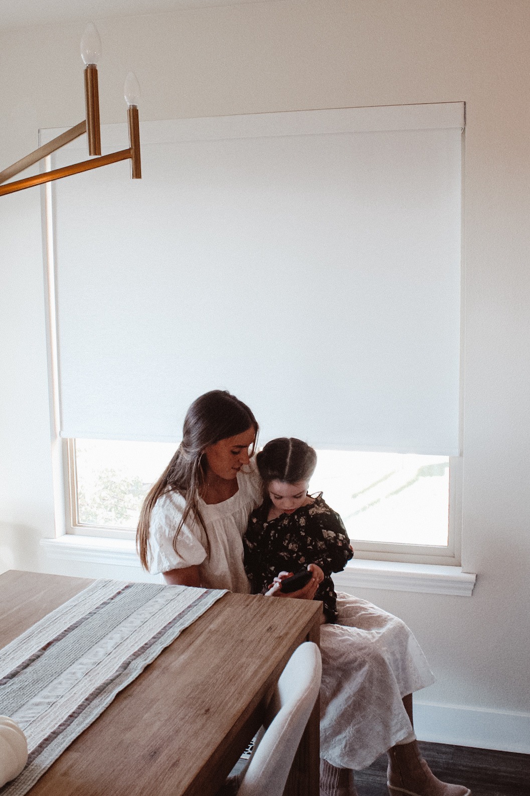 Steph and her daughter seated together by a window